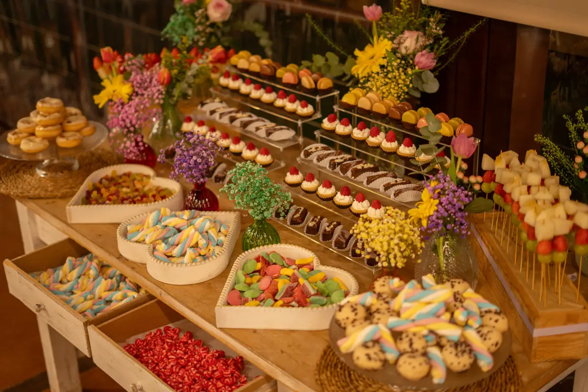 Mesa dulce decorada con macarons, cupcakes y flores
