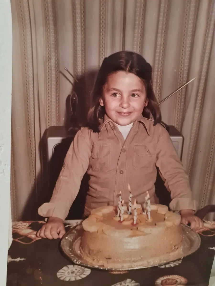 Gisela de niña, delante de una tarta de cumpleaños